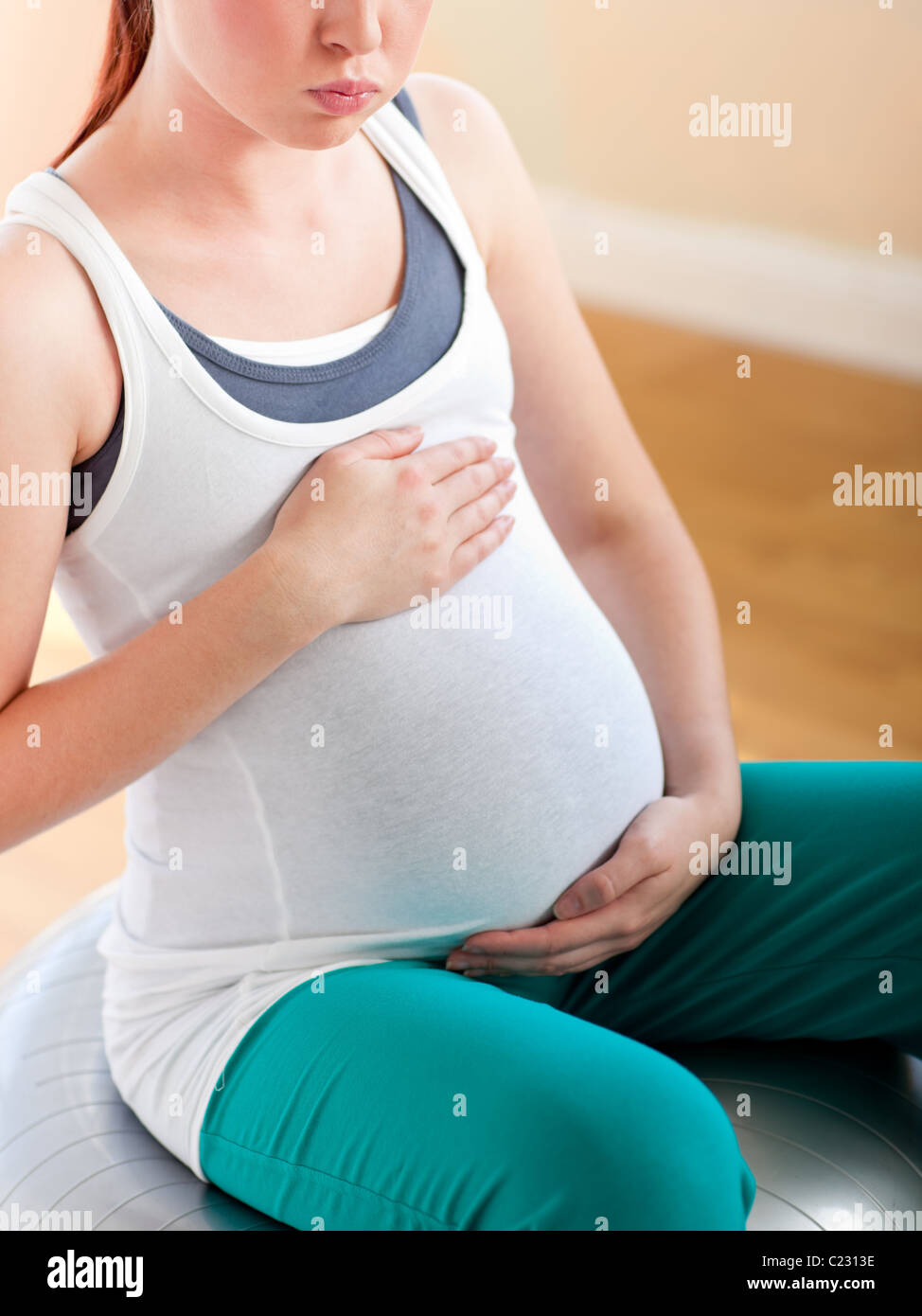 Nahaufnahme einer schwangeren Frau auf einem Ball trainieren Stockfoto