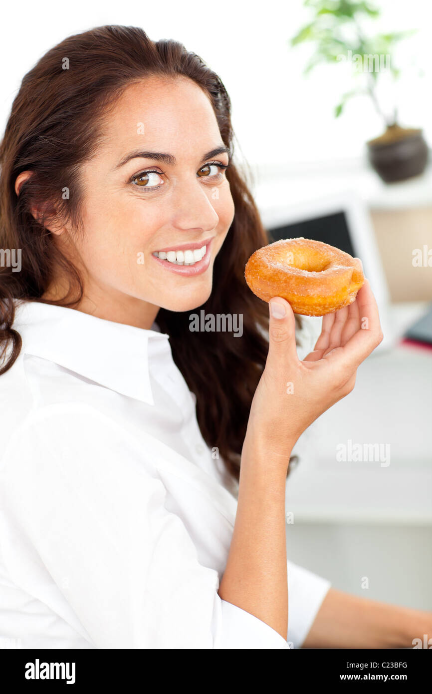 Lächelnde Geschäftsfrau hält einen Donut Stockfoto