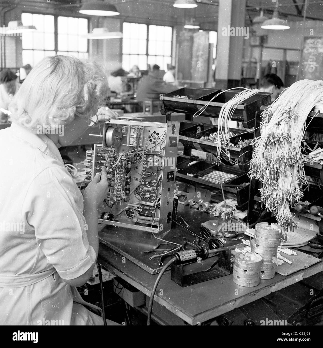 England, 1950er Jahre. Eine Fotografie von J Allan Cash von einer weiblichen Fachkraft Arbeiten auf der Rückseite des frühen TV-Gerät. Stockfoto