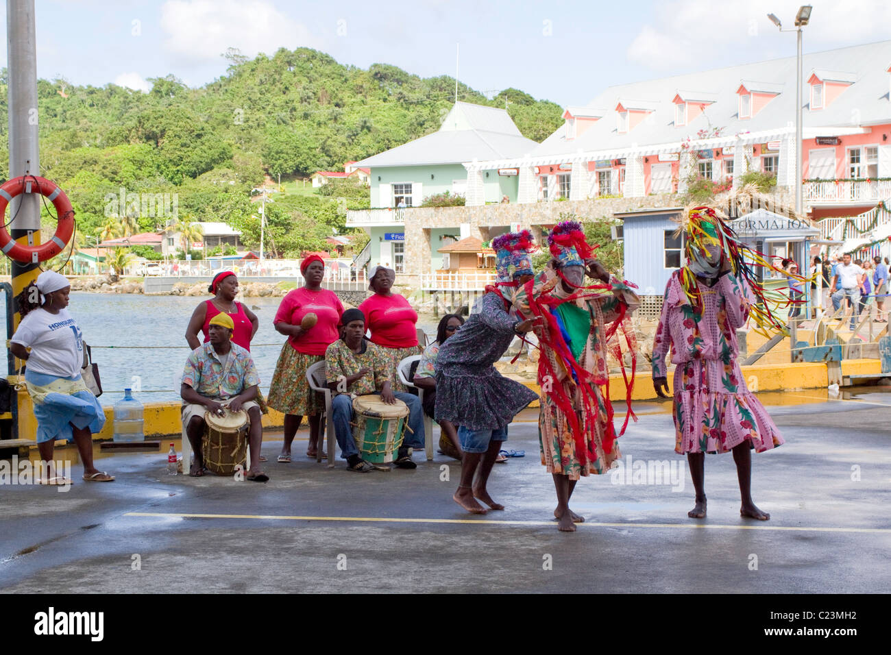 Traditionelle Tänzer vor Kreuzfahrtschiff begrüßt Touristen, Roatan, Honduras Stockfoto