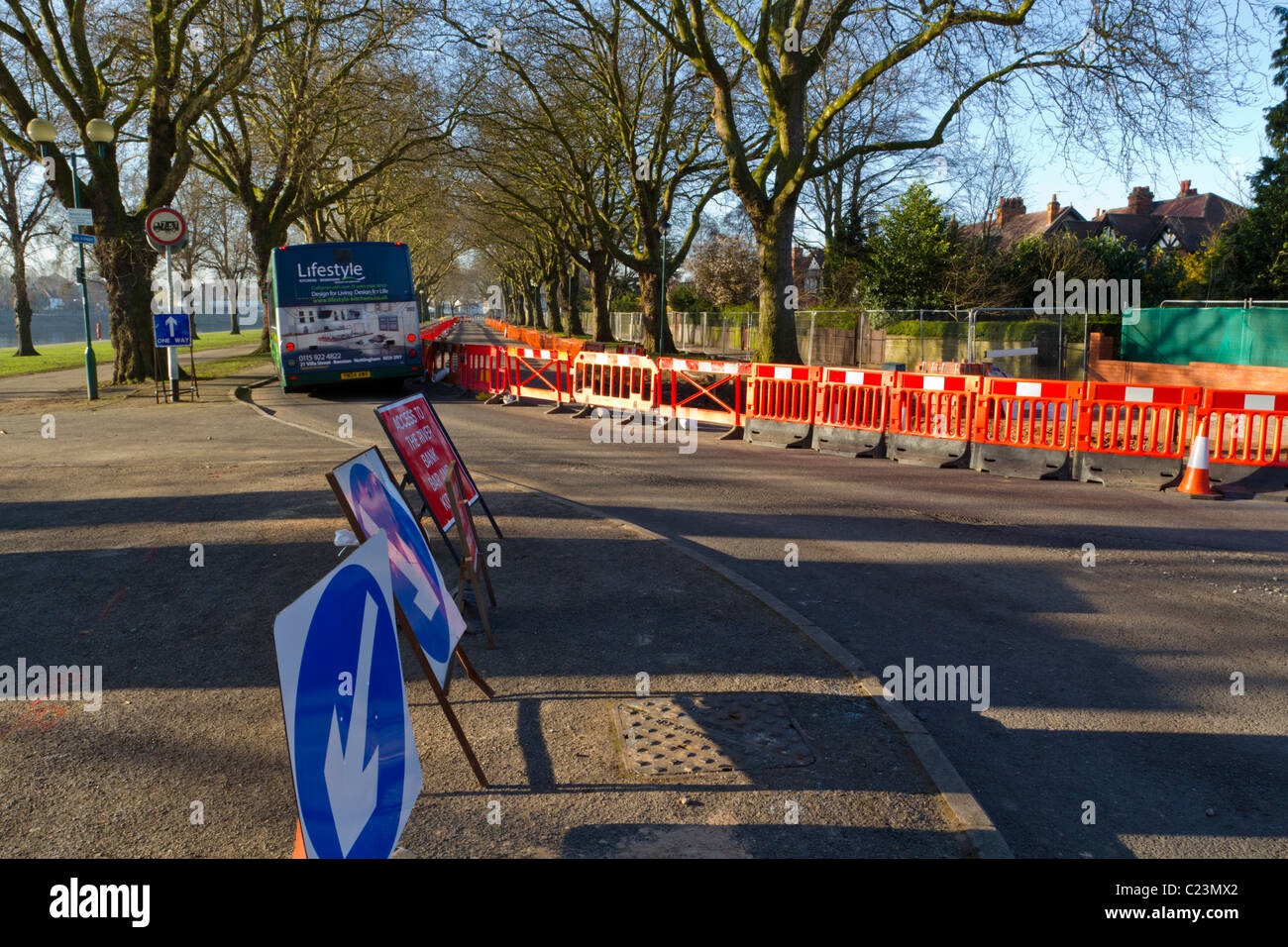 Eng. Bus einfach nur vorbei, um Kapitel 8 Kunststoff temporäre Verkehrssicherheit Barrieren an Baustellen in Nottingham, England, Großbritannien Stockfoto