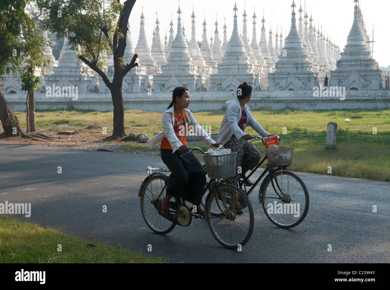 Junge Frauen mit Stupas in Mandalay Hill bkgd. Radfahren. Myanmar Stockfoto