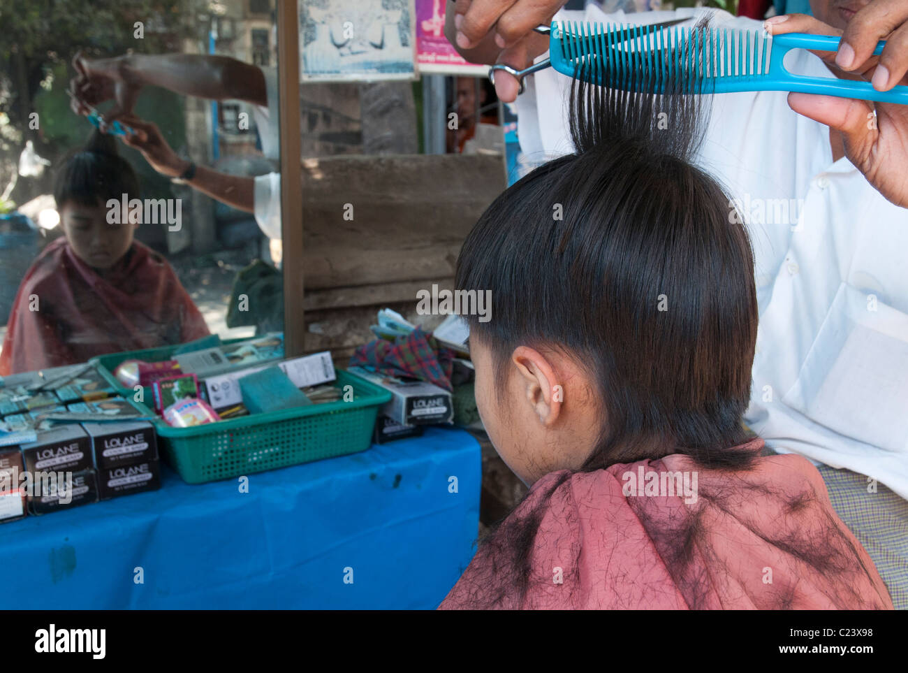 Kind mit seiner Frisur auf der Straße. Mandalay. Myanmar Stockfoto