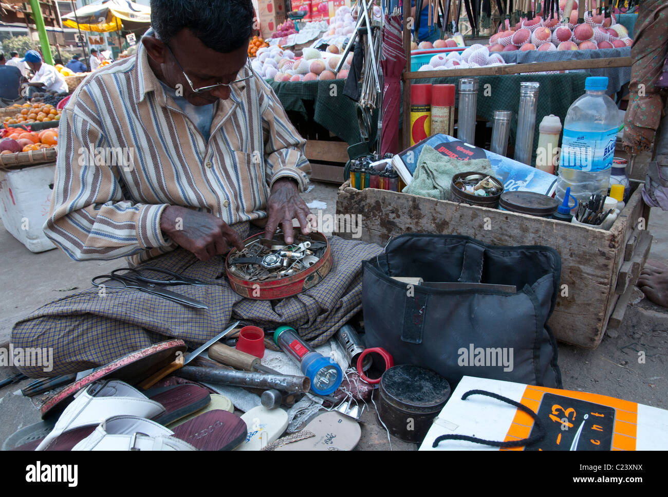 Hawcker alles auf Bürgersteig repariert. Zeigyo Markt. Mandalay. Myanmar Stockfoto