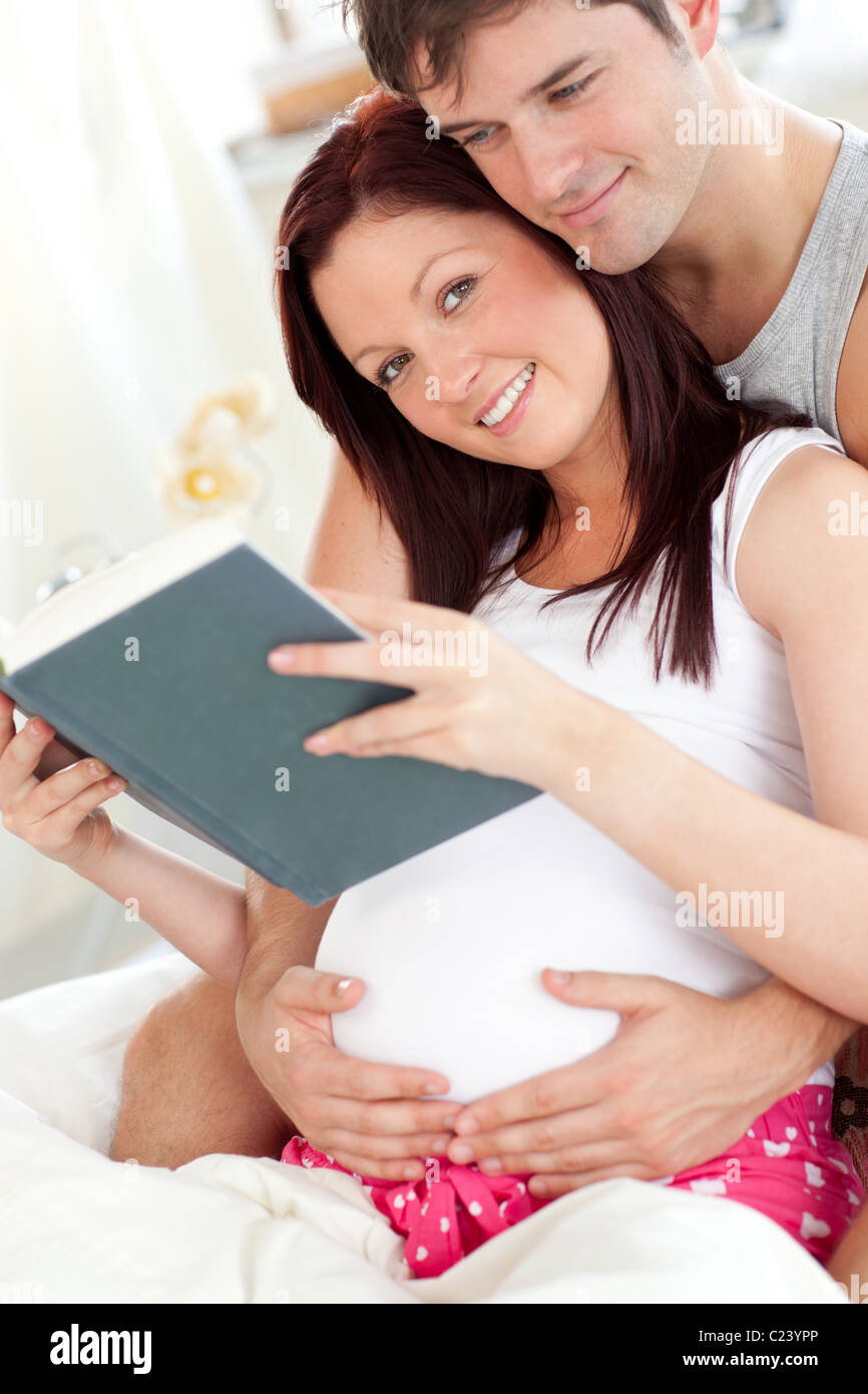 Porträt einer ziemlich schwangeren Frau und des Mannes, ein Buch zu lesen Stockfoto
