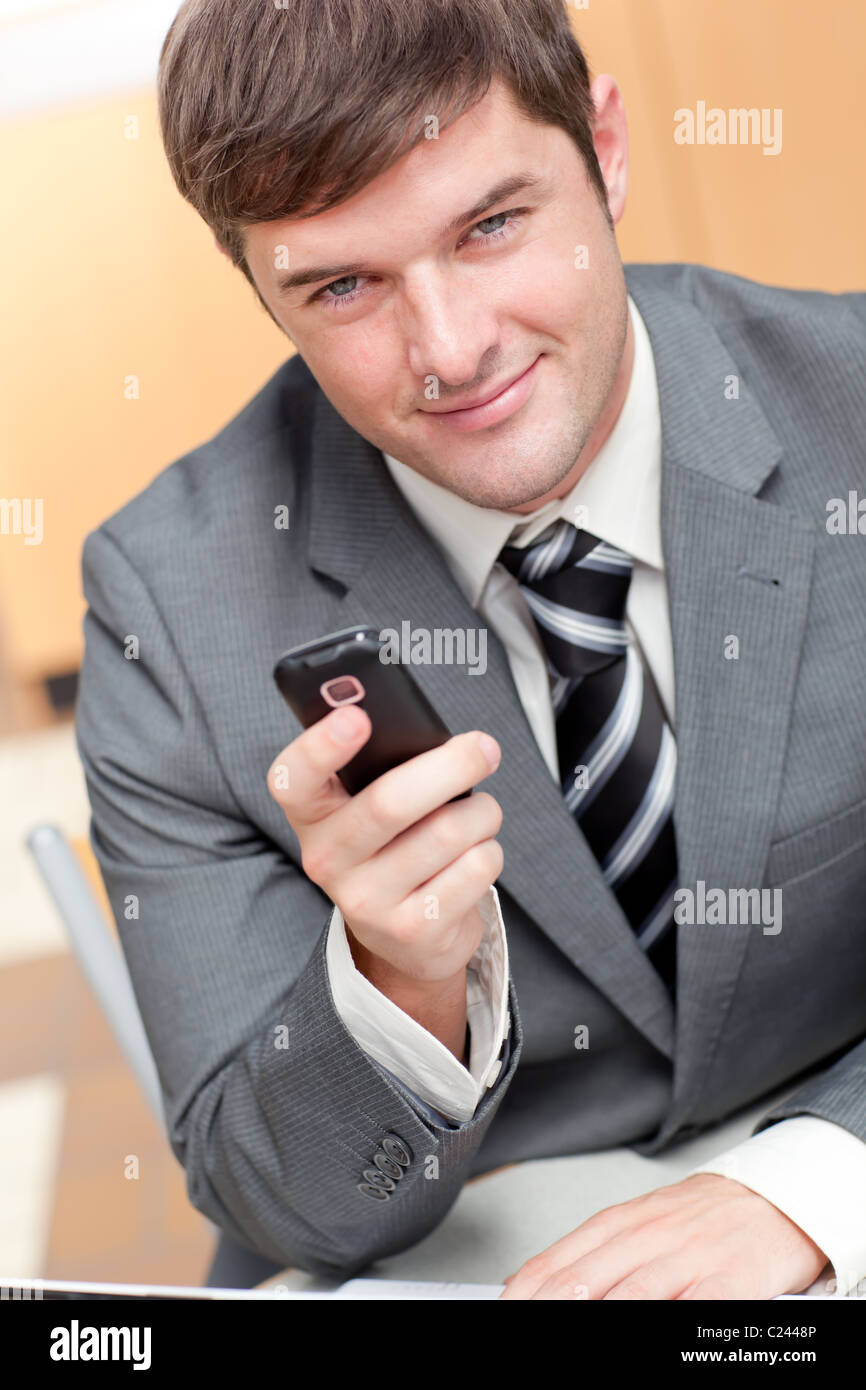 Elegante Geschäftsmann Schreiben einer Kurzmitteilung mit seinem Handy Stockfoto