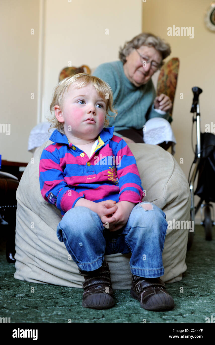 Kleiner Junge vor dem Fernseher mit Urgroßmutter Uk Stockfoto