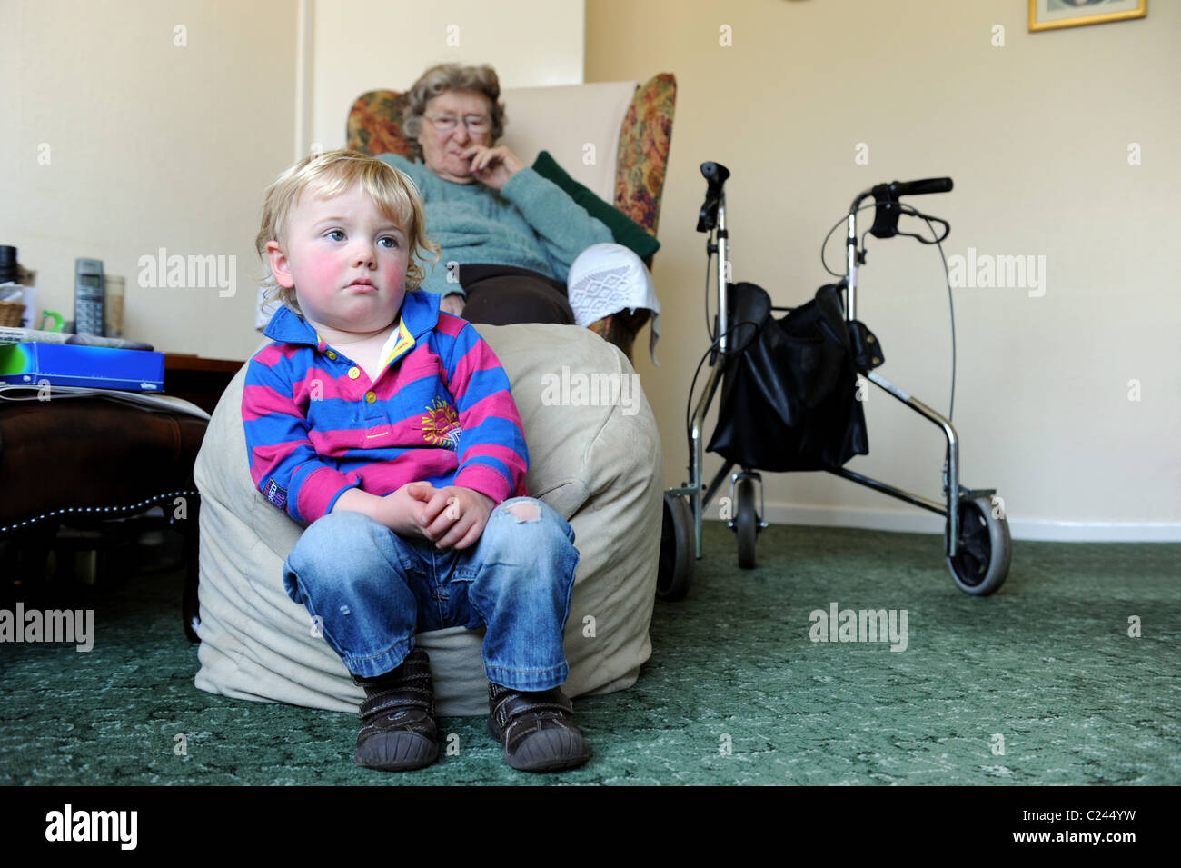 Kleiner Junge vor dem Fernseher mit Urgroßmutter Uk Stockfoto