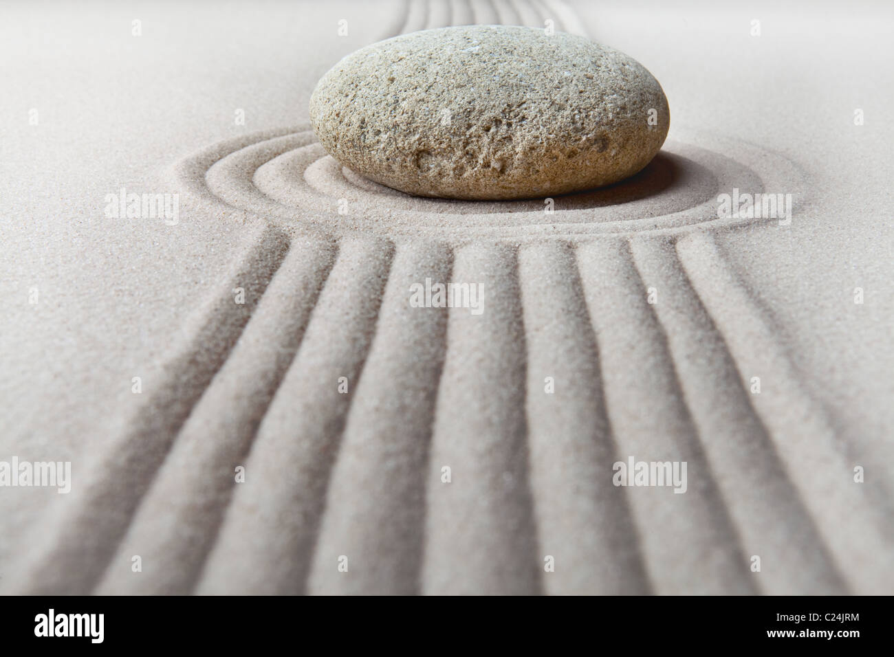 Zen Garten japanische Zen Gartenstein mit geharkt Sand und Runde Ruhe und Ausgeglichenheit Wellen Sand Steinmuster Stockfoto