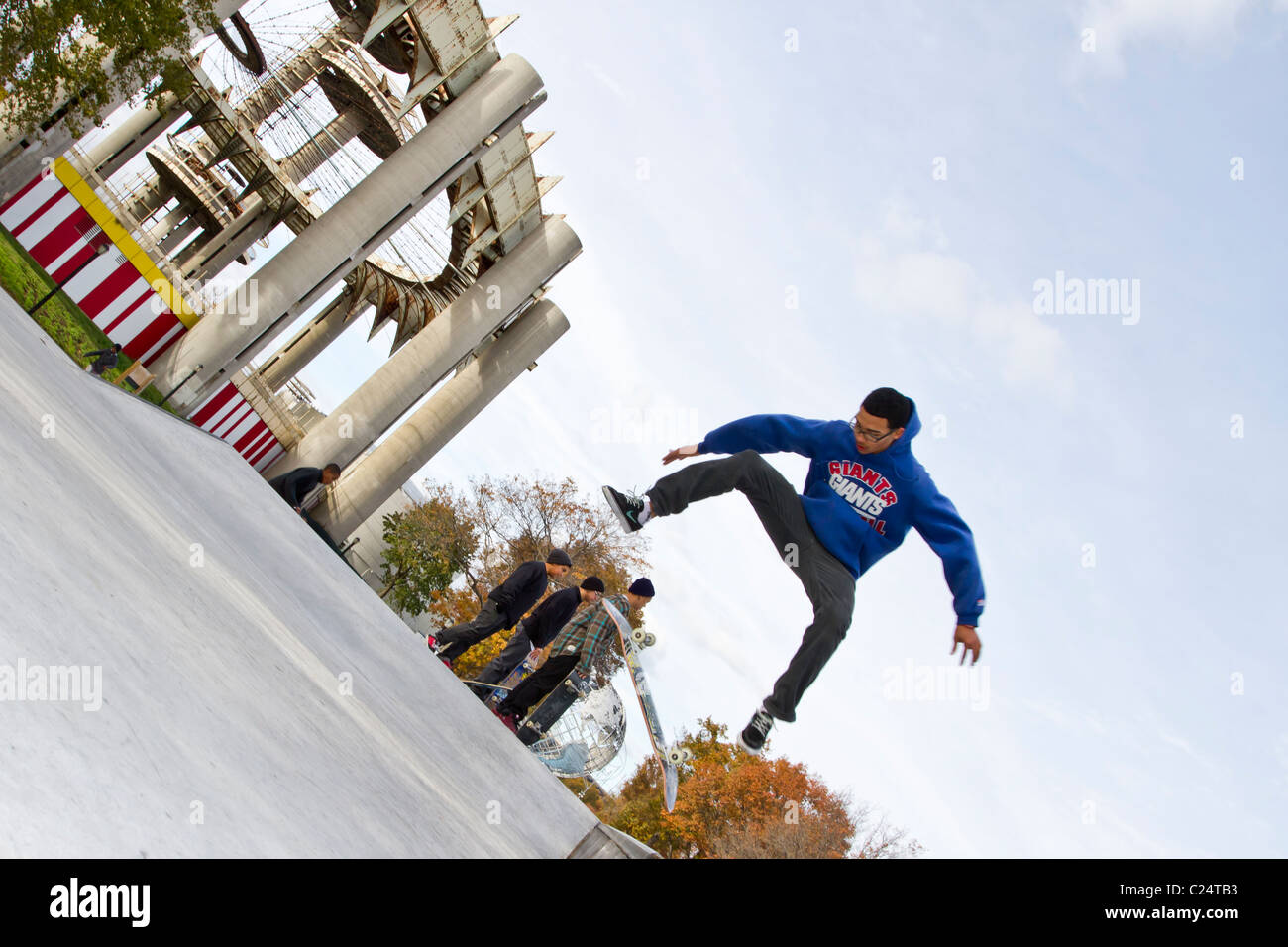 Junge Skateboarder Maloof Skatepark in Flushing Meadow Park mit den Gebäuden von der Weltausstellung 1964 im Hintergrund Stockfoto