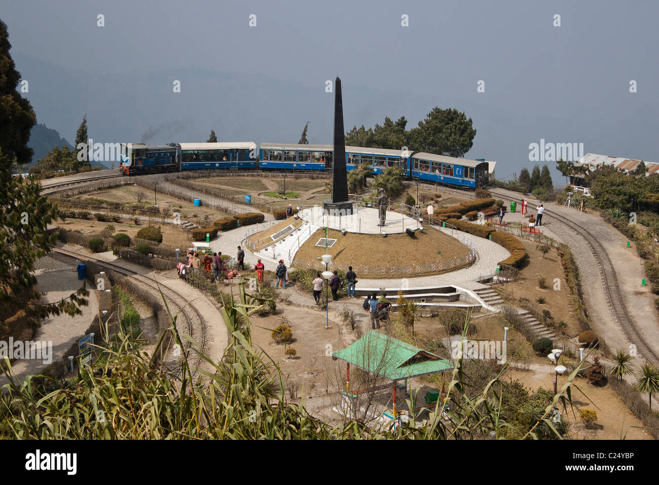 Die Spielzeugeisenbahn durchläuft Batasia Loop und das Kriegerdenkmal in Darjeeling, Westbengalen, Indien. Stockfoto