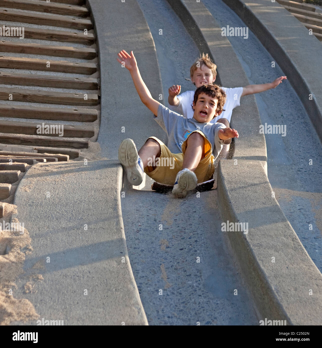 2 neun Jahre alten Jungen genießen Schiebetüren in einem Park in San Francisco. Stockfoto