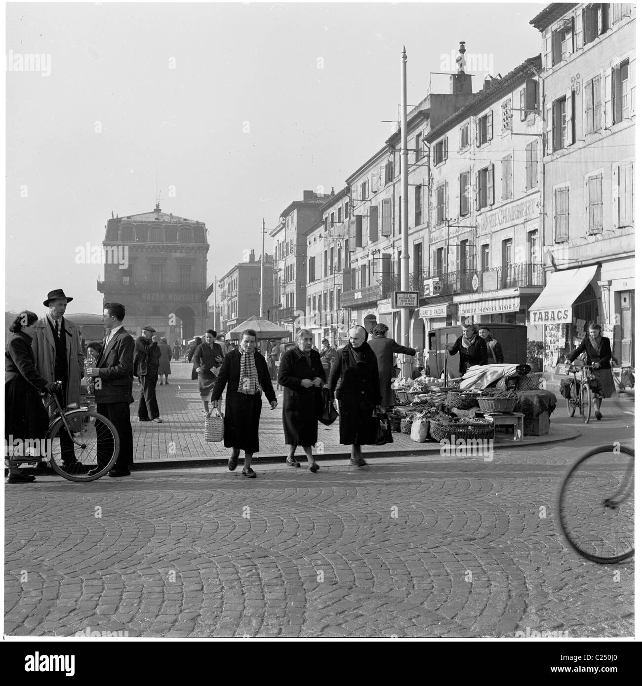 Frankreich. der 1950er Jahre. Menschen wandern die gepflasterten Marktgebiet neben dem Fluss in Castres in diesem historischen Bild von J Allan Cash. Stockfoto