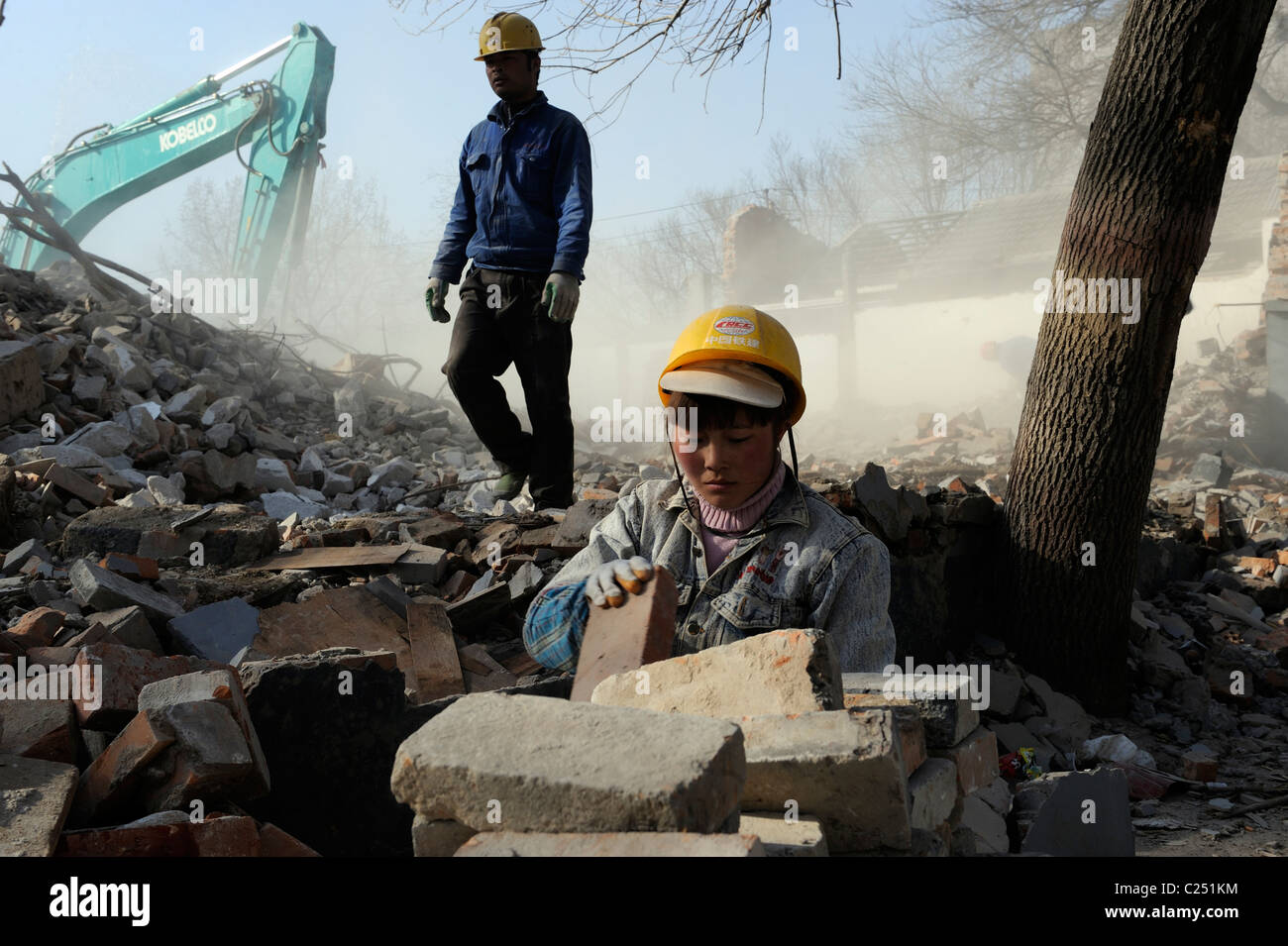 Chinesische Frau sammeln Ziegel aus Ruinen der abgerissenen Häuser im Zentrum Pekings, China.20-Mär-2011 Stockfoto