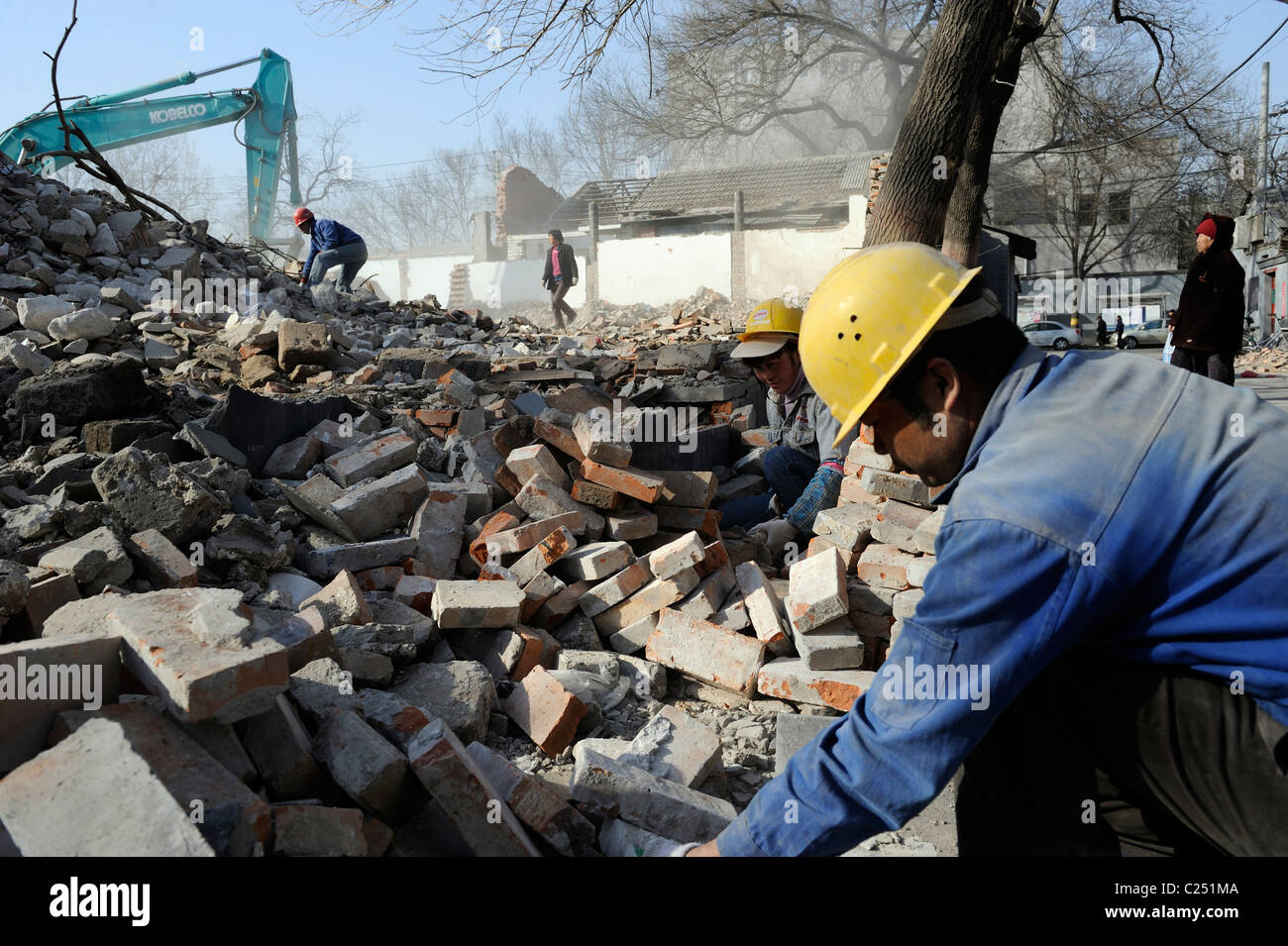 Menschen sammeln Ziegel aus Ruinen der abgerissenen Häuser im Zentrum Pekings, China.20-Mär-2011 Stockfoto
