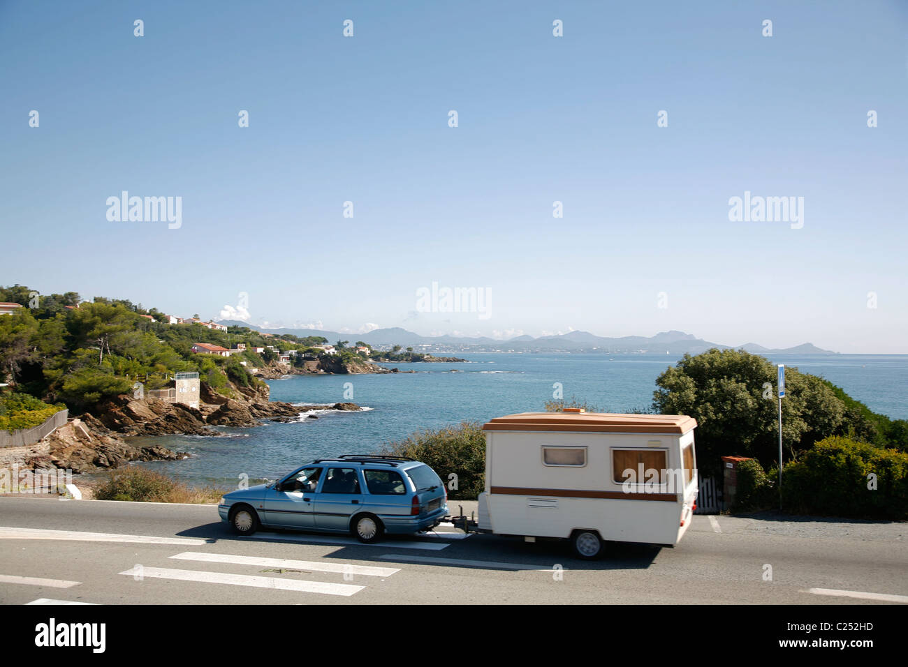 Auto abschleppen Wohnwagen fährt entlang der Küste in der Nähe von Fréjus, Provence, Frankreich. Stockfoto