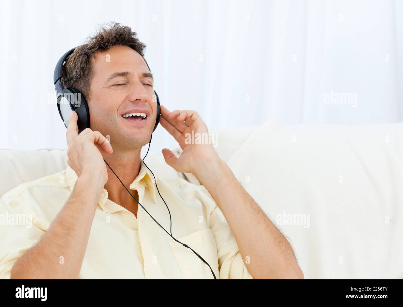 Ruhiger Mann Musik hören auf dem sofa Stockfoto