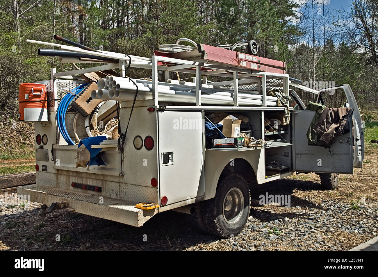 Ein LKW beladen mit Werkzeugen und Ausrüstung für einen Klempner auf einer Baustelle. Stockfoto