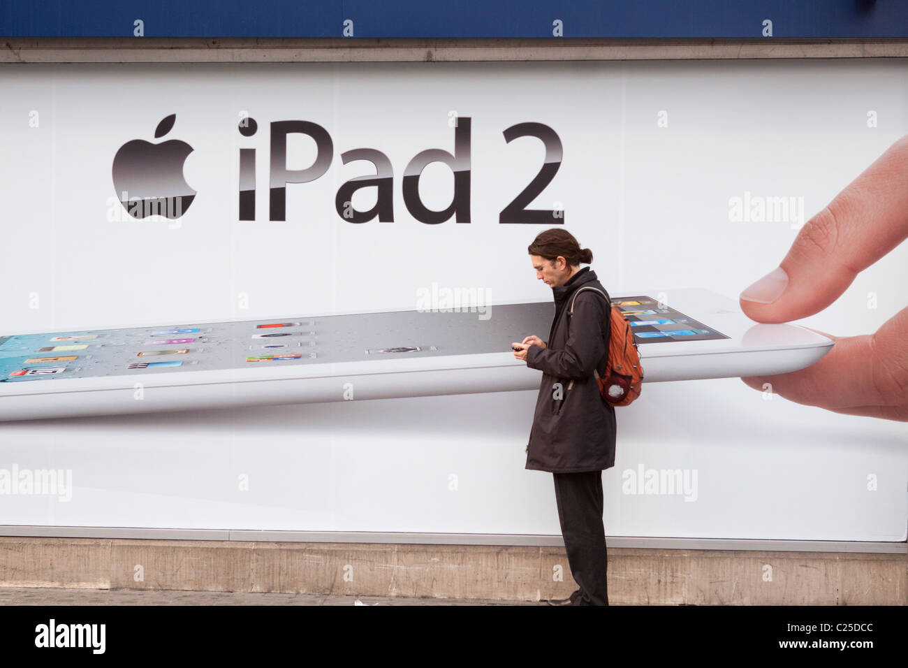 Der Mensch steht vor Plakatwerbung das iPad 2 von Apple Inc. Stockfoto