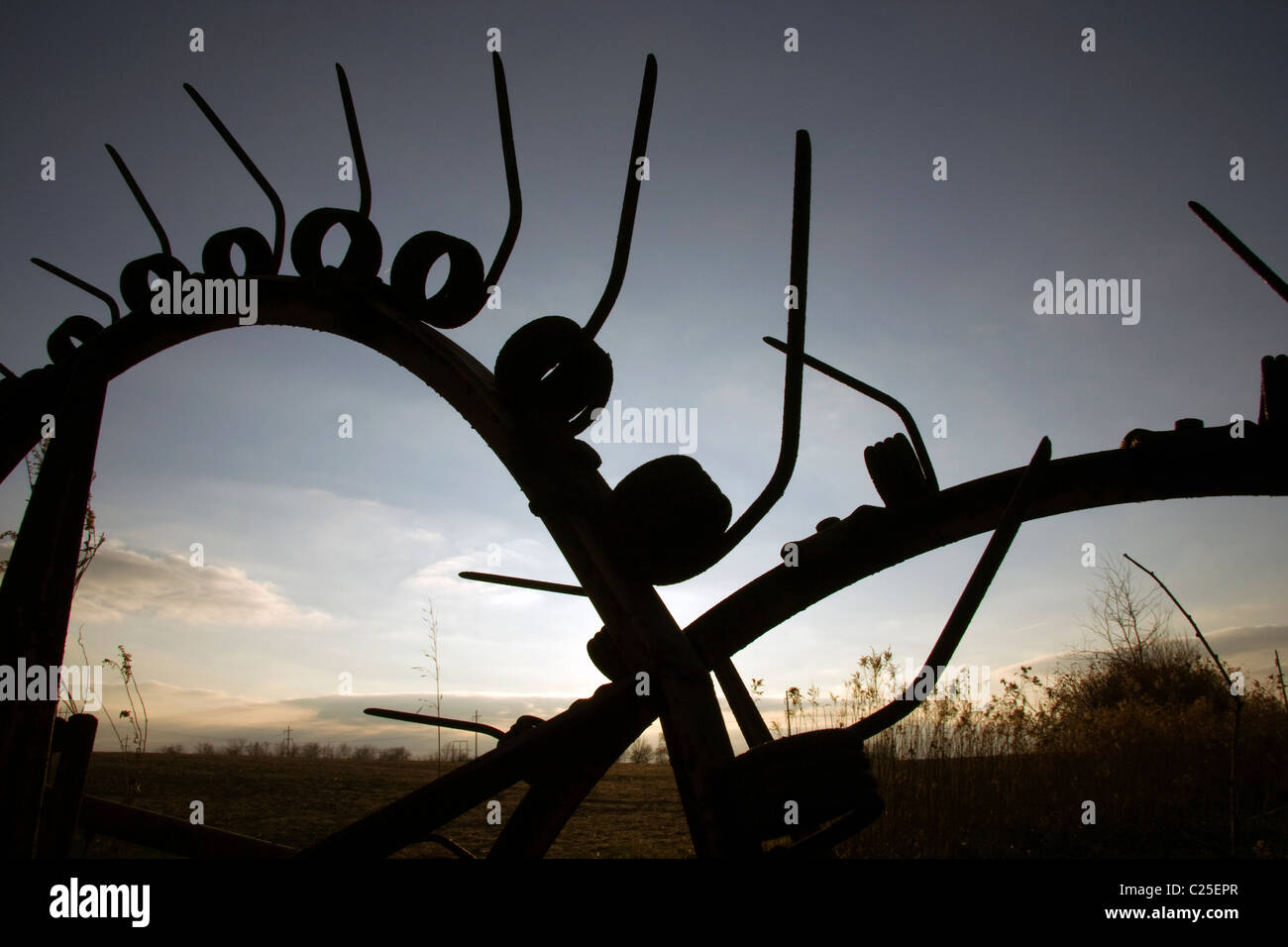 Alte Landmaschinen am Sonnenuntergang. Stockfoto