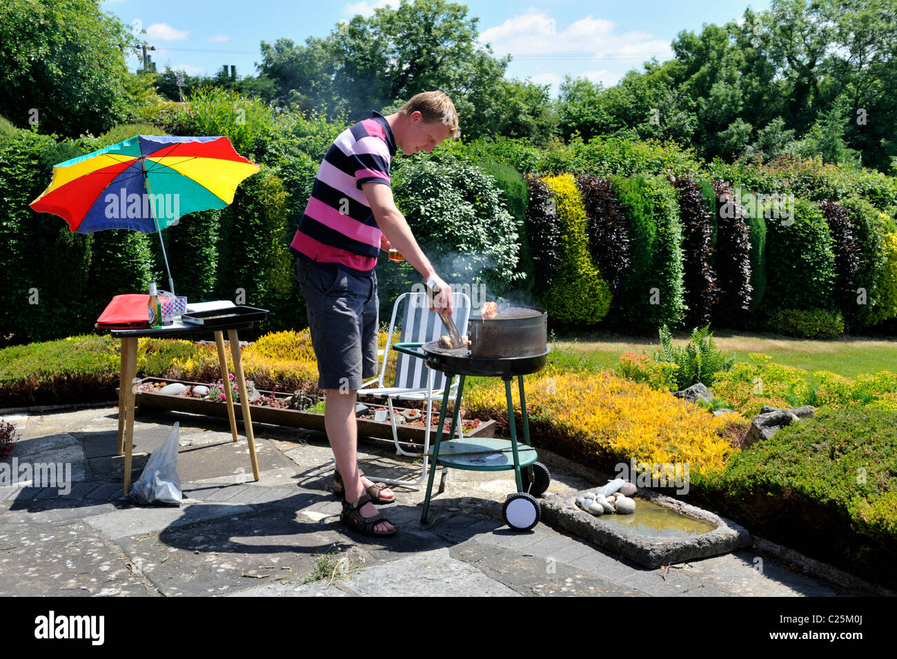 Mann, Kochen am Grill im Garten Stockfoto