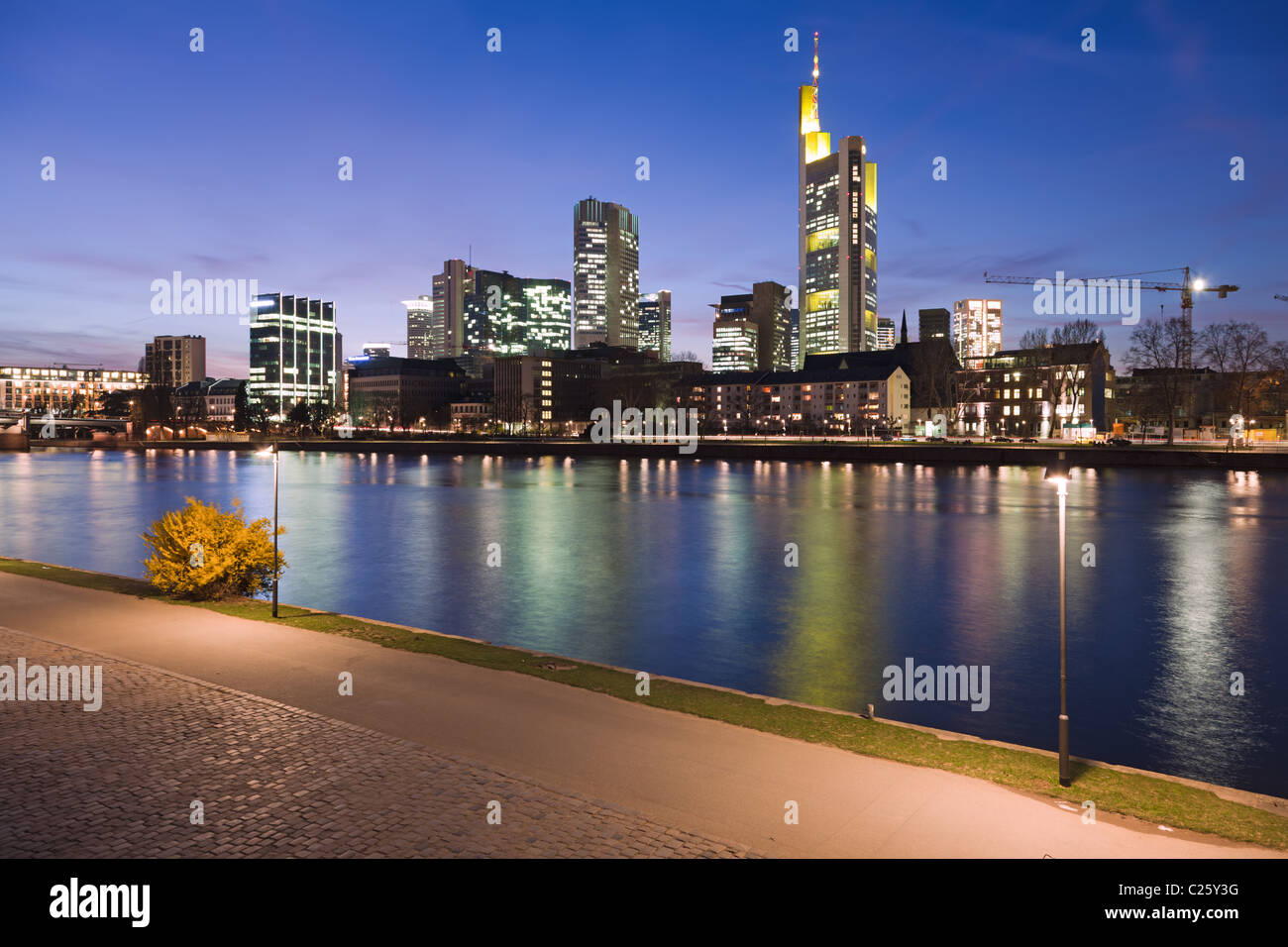 Der Fluss Main bei Frankfurt, Deutschland, mit der Skyline der Stadt in der Dämmerung. Stockfoto