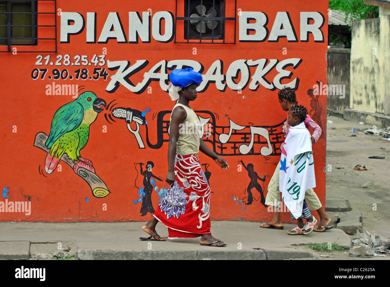Die Menschen gehen vorbei an einer Karaoke-Bar in Abidjan, Elfenbeinküste Stockfoto