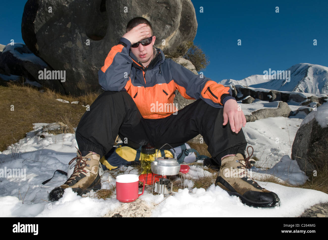 Ein müde Winterwanderer wartet darauf, dass der Wasserkocher zum Kochen Stockfoto