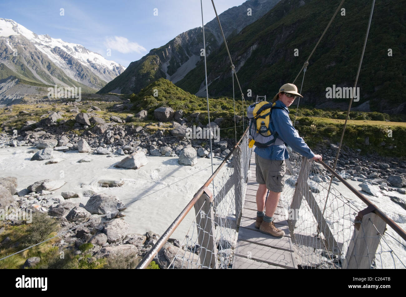 Ein Wanderer überqueren den ersten Hooker Valley Drehbrücke, auf dem Weg für den Gletschersee, Südinsel von Neuseeland Stockfoto