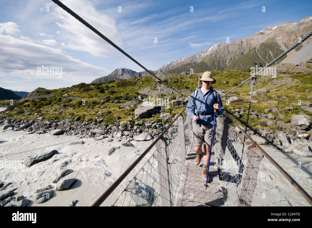 Ein Wanderer überqueren den ersten Hooker Valley Drehbrücke, auf dem Weg für den Gletschersee, Südinsel von Neuseeland Stockfoto