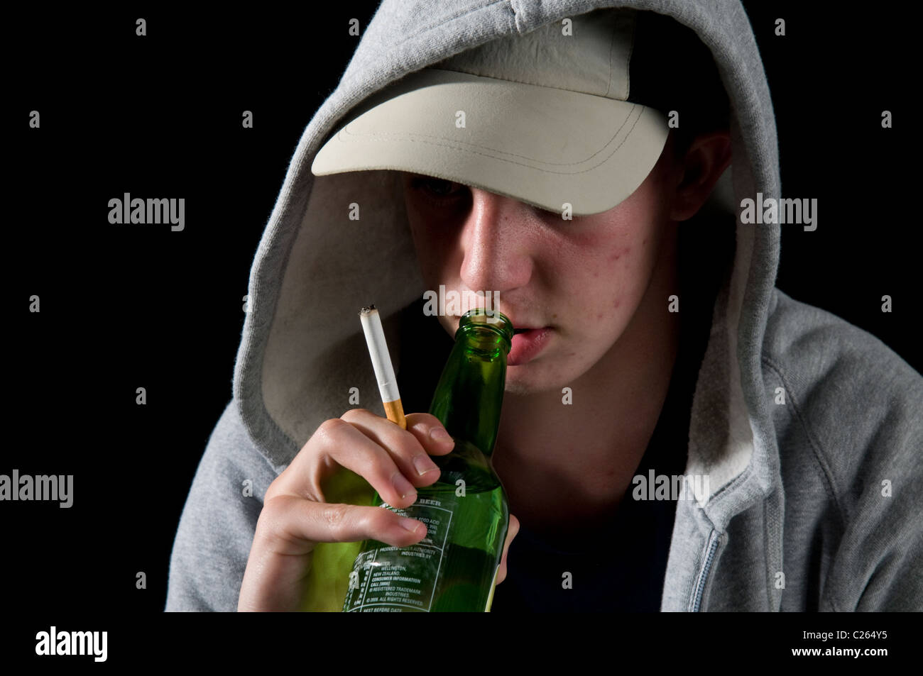 Teenager Boy in hoody Rauchen und trinken Stockfoto