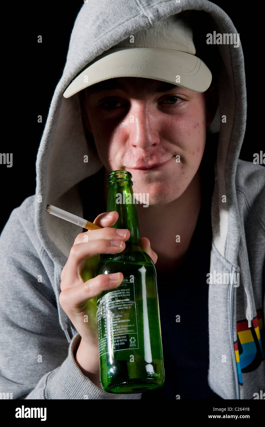 Teenager Boy in hoody Rauchen und trinken Stockfoto