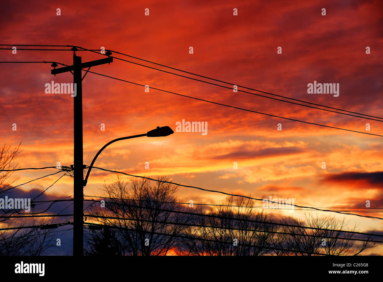 Sonnenuntergang über den Strom Post und Kabel einer Kleinstadt. Stockfoto