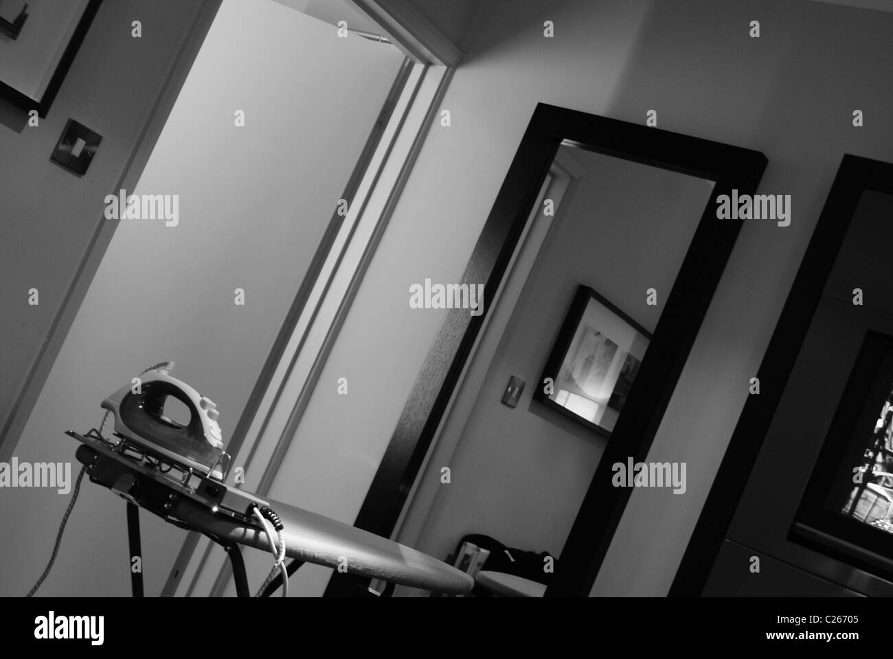 Ein Hotelzimmer mit Bügeleisen, Bügelbrett und Spiegel Stockfoto