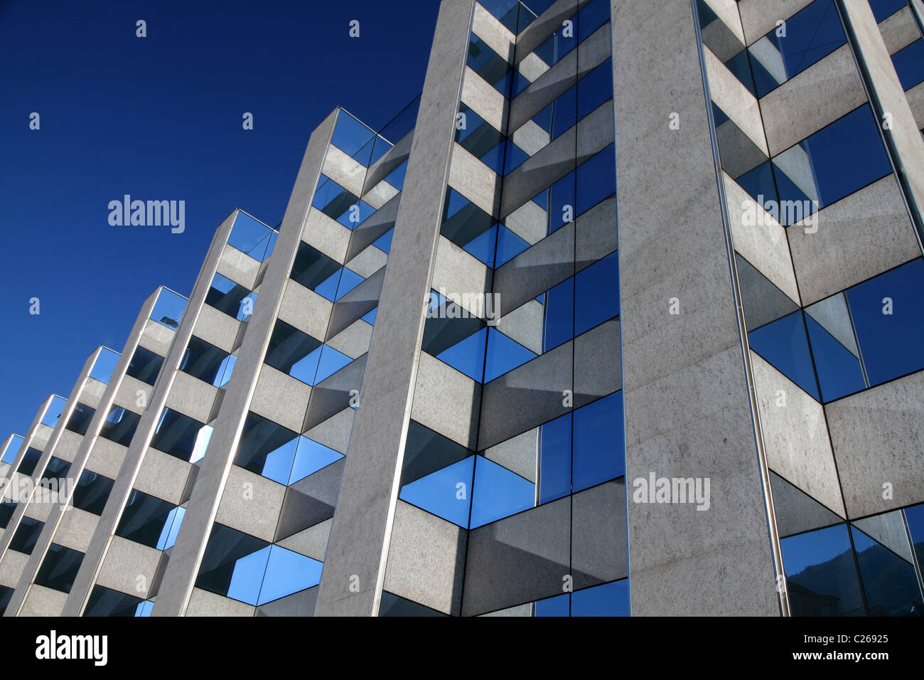moderne symmetrische Bürogebäude Fassade mit reflektierenden Windows vor einem blauen Himmel Stockfoto