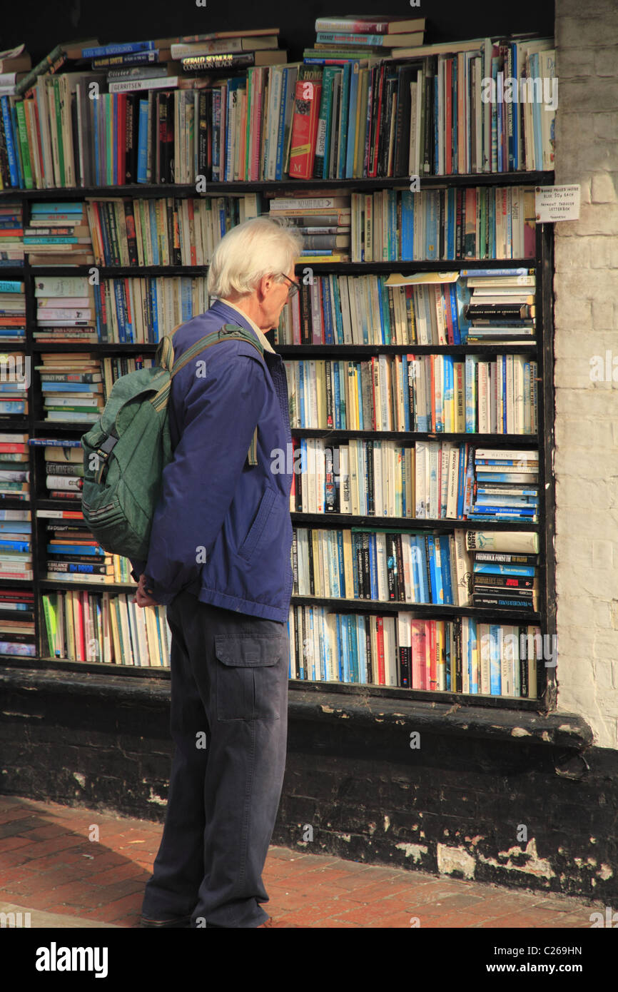 Ein Mann prüfend die Buchregale außerhalb ein Secondhand-Buchladen in Eastbourne, East Sussex, England. Stockfoto