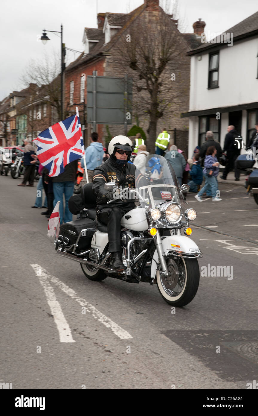 Patriotische Harley Davidson Motorradfahrer die Union Jack Flagge, wie er seine nach unten Wootton Bassett High Street Radtouren Stockfoto