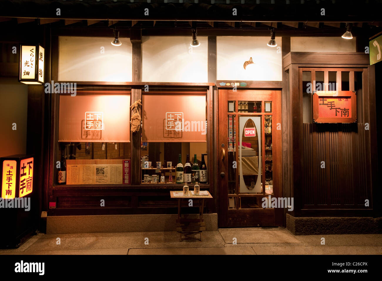 Exterieur des Restaurant mit lokal gebrauten Sake (Reiswein) Flaschen im Fenster im historischen Grachtenviertel Bikan in der Nacht. Stockfoto