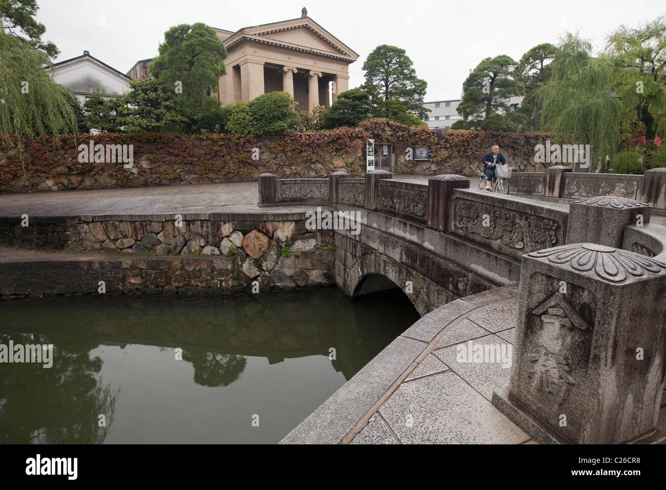 Steinerne Brücke Kreuzung Kanal Bikan historischen Viertel mit Ohara Museum of Art im Hintergrund, Kurashiki, Japan. Stockfoto