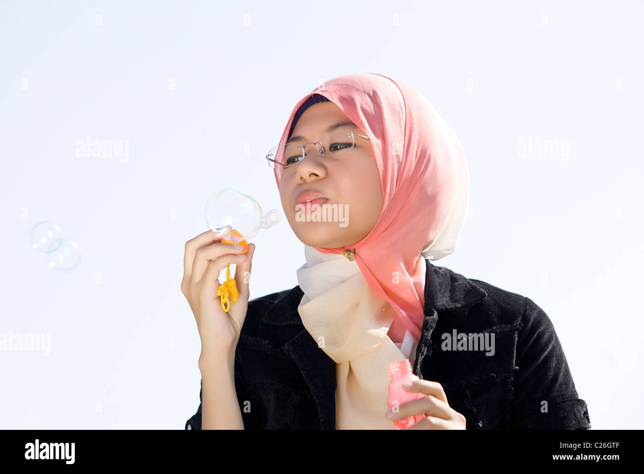 Junge muslimische Mädchen Spiel mit Seifenblasen Stockfoto
