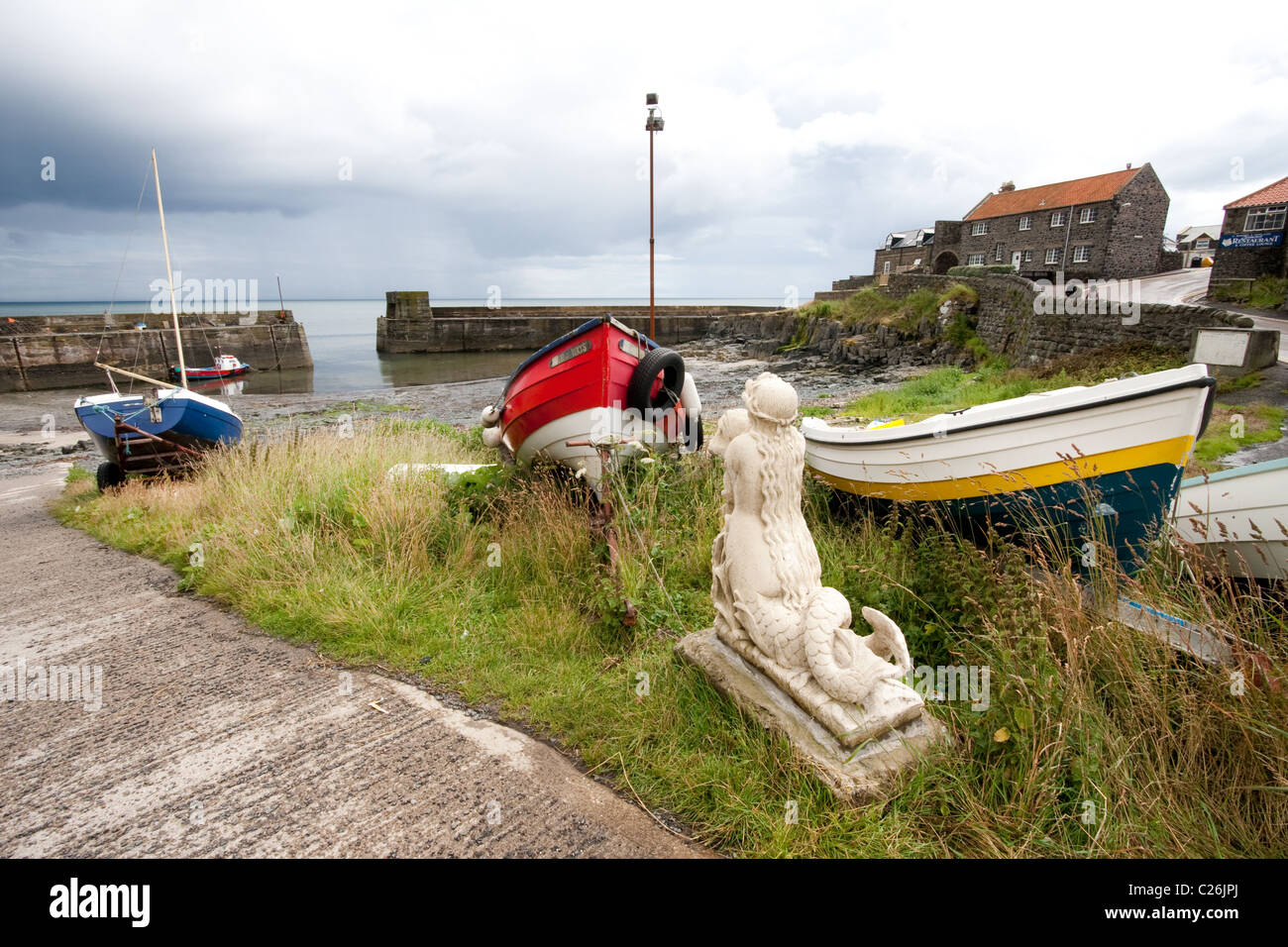 Statue von einer Meerjungfrau mit Booten im kleinen Dorf Port von Craster Northumberland Stockfoto
