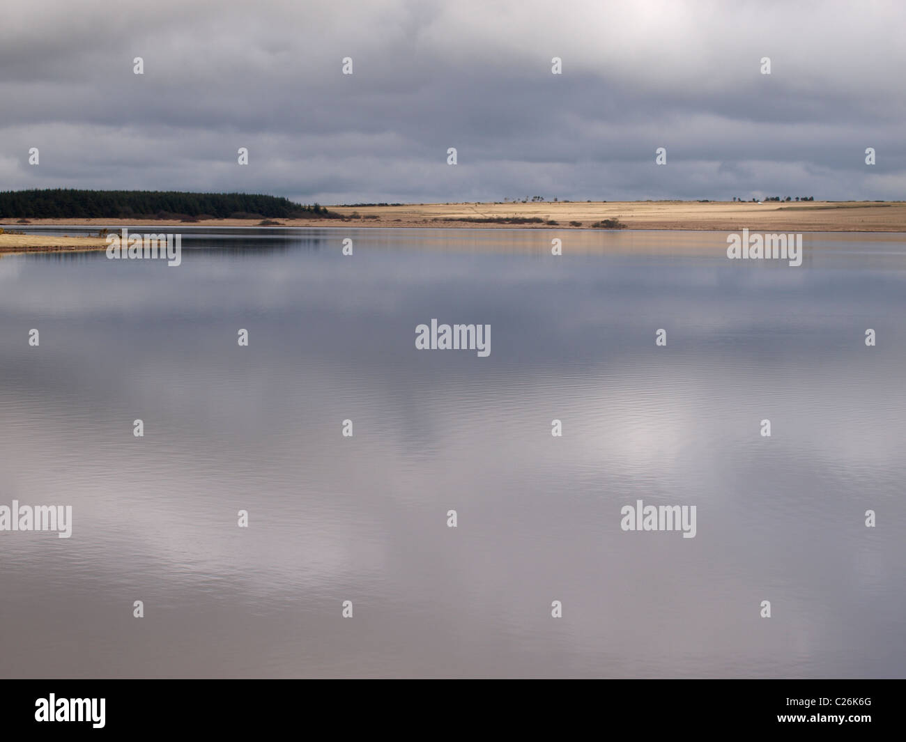 Grauen Himmel spiegelt sich in einem See überlaufen Reservoir, Cornwall, UK Stockfoto