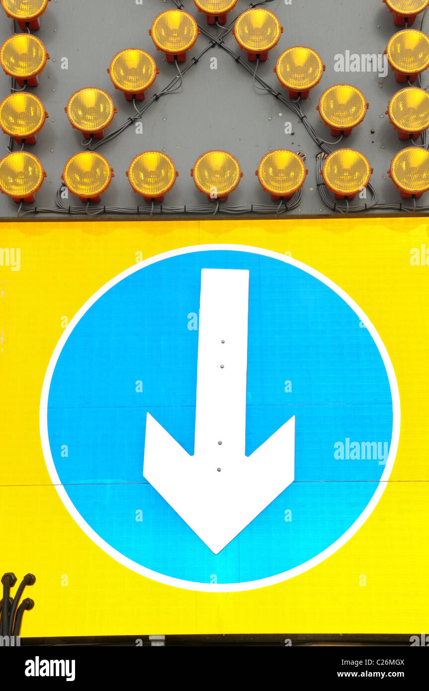 Große Straße Verkehrsschild mit einem Pfeil nach unten und eine Reihe von blinkenden Lichtern darüber Stockfoto