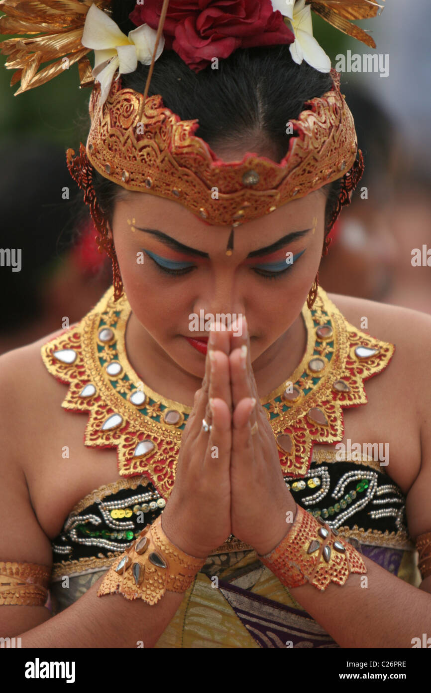 Balinesische Frau verbeugte sich während eines Kekak-Tanzes bei Ulu Watu Tempel, Bali. Stockfoto