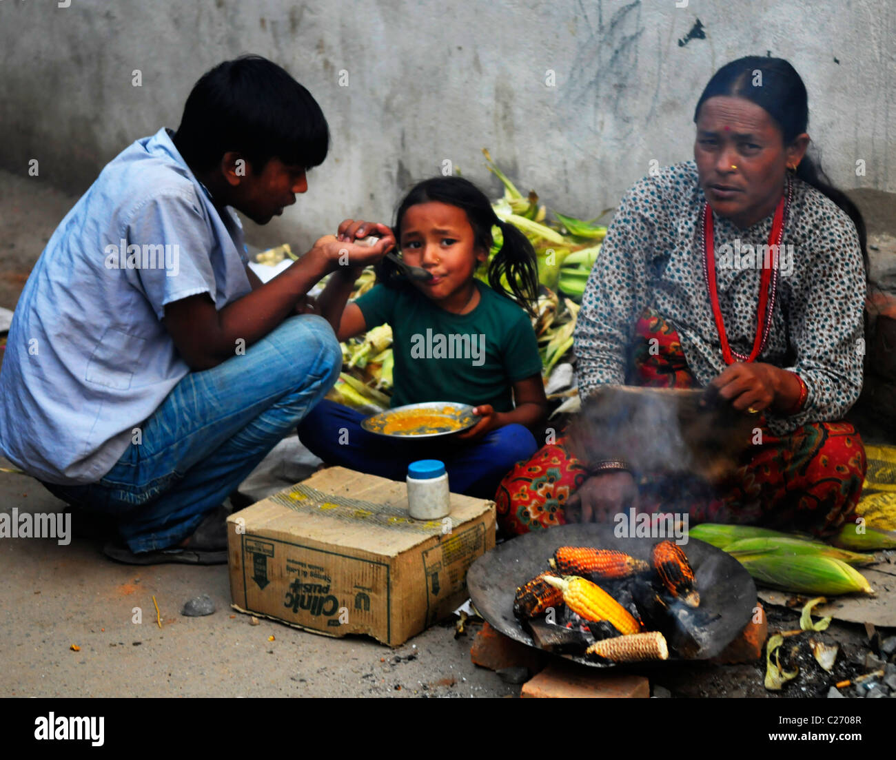 nepalesischen Familie Maiskolben zu verkaufen, um zu überleben, die Nepalesen Leben in Kathmandu, Kathmandu Straße leben, nepal Stockfoto