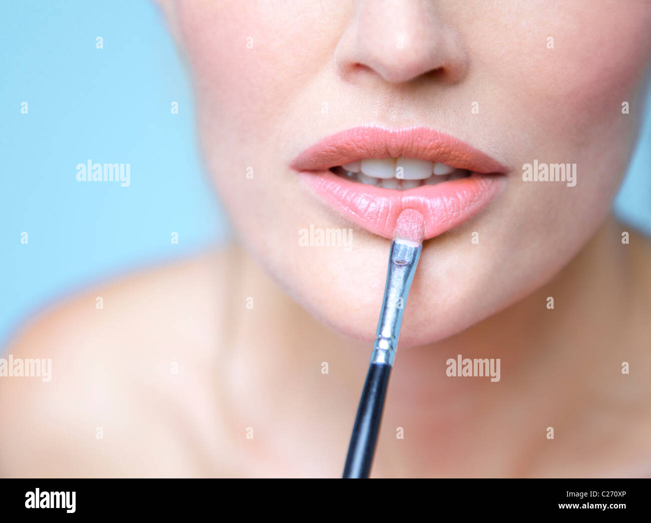 Frau Anwendung Lippenstift mit Make-up Pinsel - Nahaufnahme Stockfoto