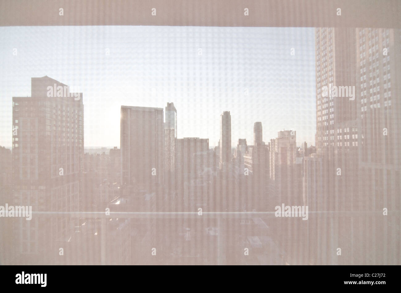 Ein Blick durch ein Blind von der Midtown-Wohnung in Manhattan, New York City. Das Empire State Building steht hoch auf der rechten Seite. Stockfoto