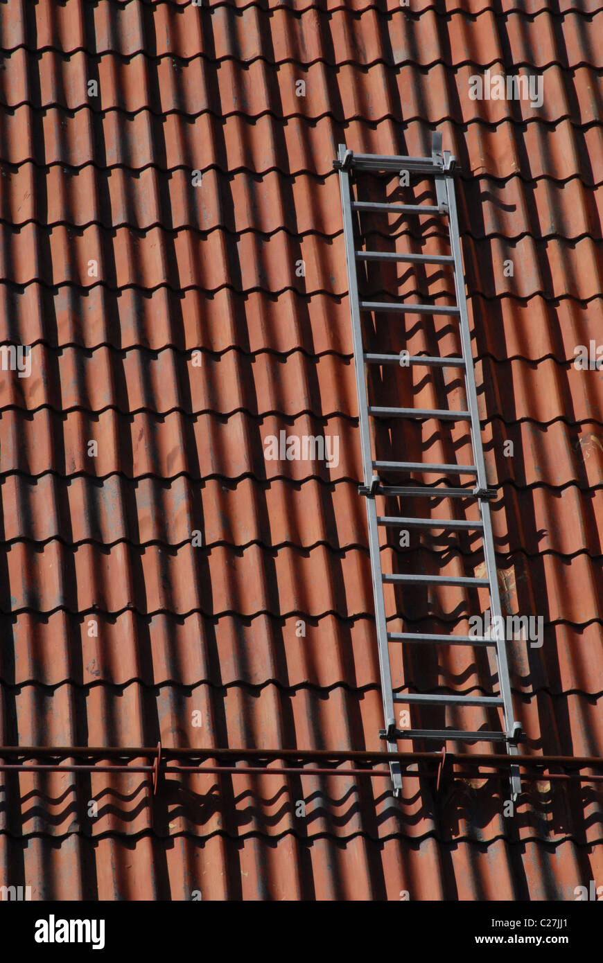 Dach-Leiter auf sonnigen Ziegeldach. Stockfoto