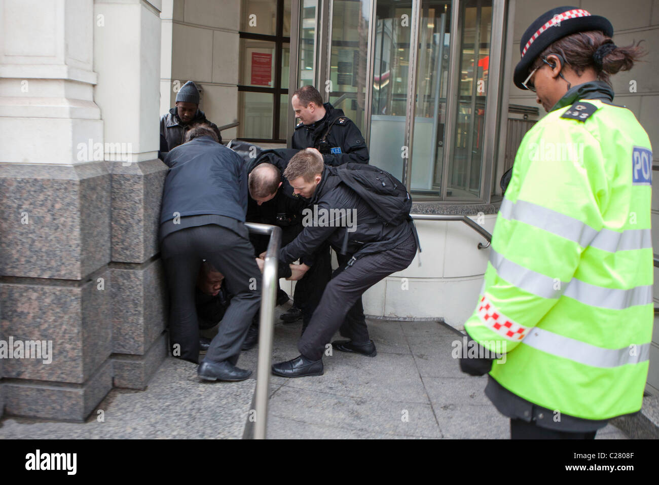 Ein junger schwarzer Rüde ist am Ludgate Hill verhaftet. Es dauerte 10 Polizisten aus verschiedenen Kräfte zu überwinden und ihn verhaften. Stockfoto