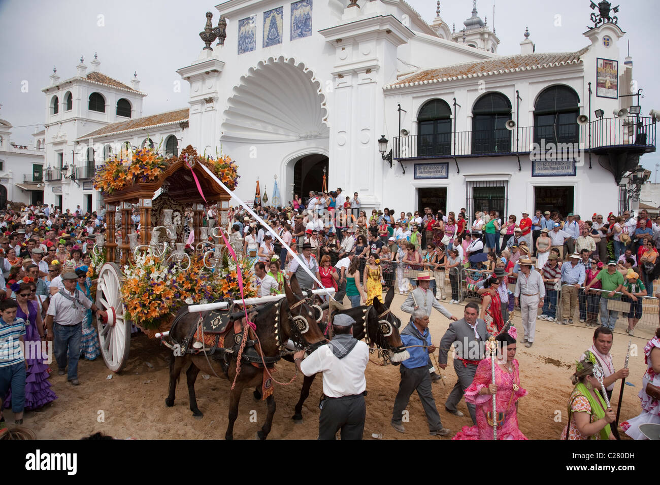 Ein Wagen, gezogen von Maultieren wird vor der Hauptkirche in El Rocio, Andalusien während der jährlichen Wallfahrt nach El Rocio verarbeitet. Stockfoto